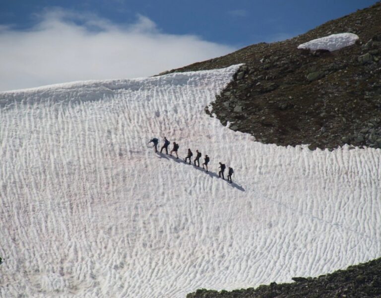 Groep wandelaars beklimt een besneeuwde berghelling